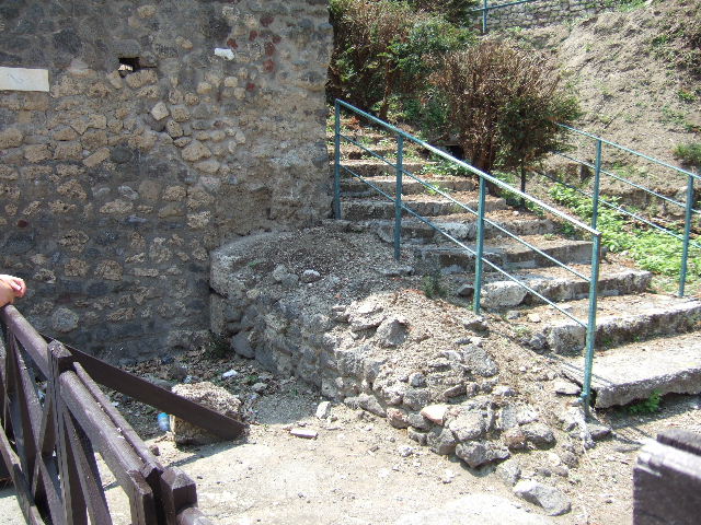 VI.7.26 on right.  From model in Naples Archaeological Museum.  North end of VI.9.1 on left showing site of street altar and wall now gone. 
