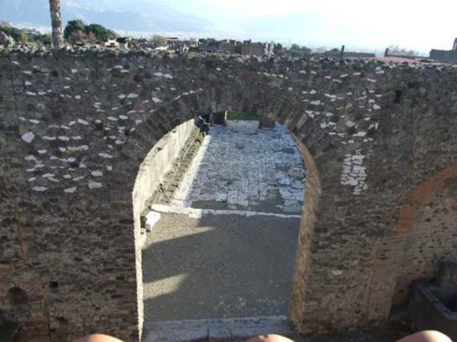 Arched entrance in north-west corner of Forum. December 2007. Looking down from roof of restaurant at VII.5.19.
