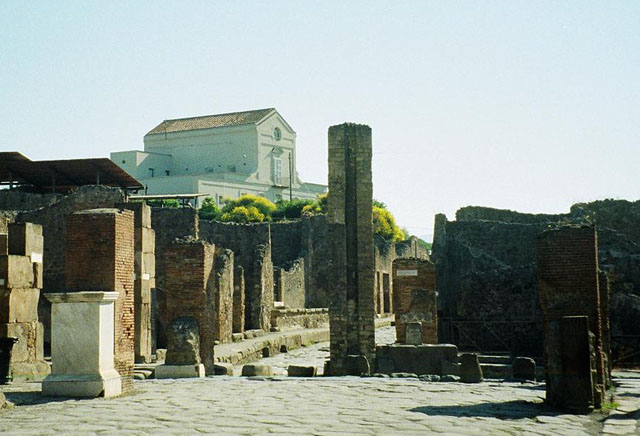 Arch of Marcus Holconius Rufus. May 2010. Site of arch at Holconius’ crossroads.
This was a large arch at the major crossroads of Via dell’Abbondanza and Via Stabiana 
Looking east along Via dell’Abbondanza to junction with Via Stabiana.
According to Liselotte Eschebach this is a Tetrapylon.
See Eschebach, L., 1993. Gebäudeverzeichnis und Stadtplan der antiken Stadt Pompeji. Köln: Böhlau. (Pages 244-5).
According to Wikipedia, A tetrapylon (Greek: Τετράπυλον, "four gates") is an ancient type of Roman monument of cubic shape, with a gate on each of the four sides: generally it was built on a crossroads.
