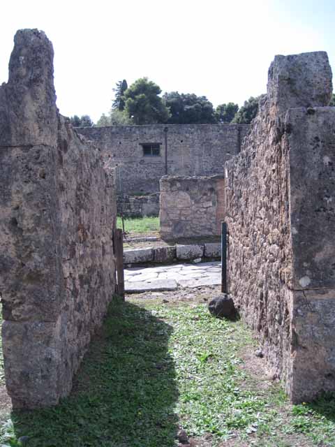 I.2.3 Pompeii. December 2006. North and east side of Triclinium on lower level, with a large block of Vesuvian lava from pre-historic times. To the north on the higher level are the remains of house number I.2.6. This area was bombed in September 1943. The impluvium was destroyed, and the three rooms to the north of the atrium, together with the north wall separating the two houses were demolished. See Van der Poel, H. B., 1986. Corpus Topographicum Pompeianum, Part IIIA. Austin: University of Texas. (p.4) See Garcia y Garcia, L., 2006. Danni di guerra a Pompei. Rome: L’Erma di Bretschneider. (p.37-38)