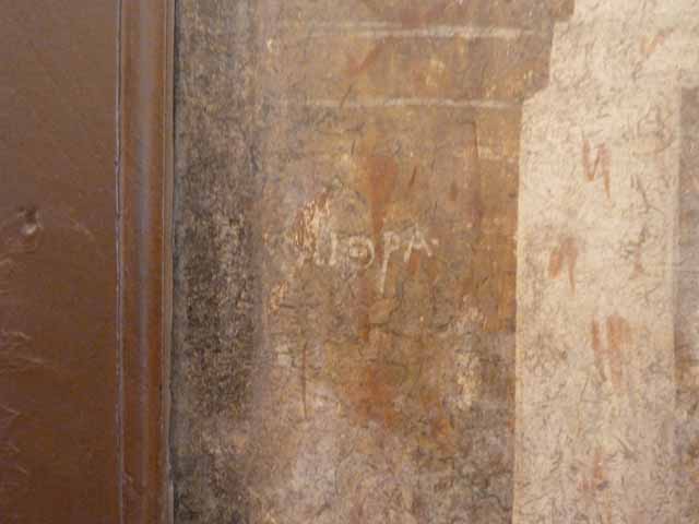 I.2.6 Pompeii.  May 2010. Detail from the wall painting of the Theft of the Palladium (Ratto del Palladio) found on the south wall of the triclinium. 
Top of column on left side of painting.  Now in Naples Archaeology Museum, inventory number: 109751

