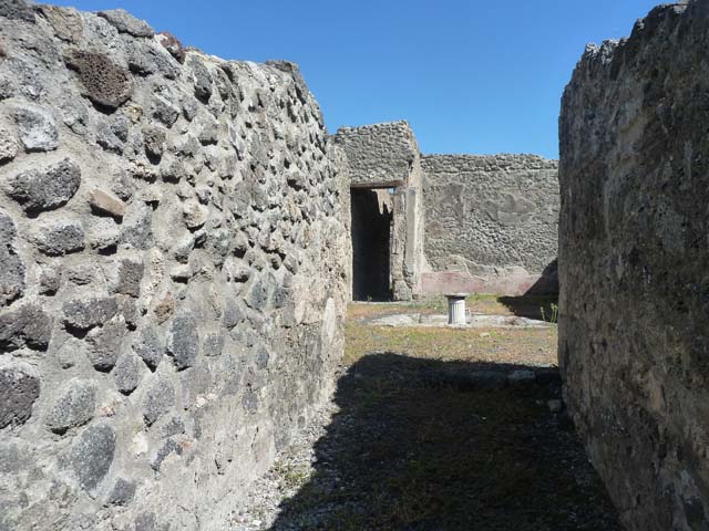 I.2.10 Pompeii. September 2004. The triclinium is in centre of picture behind right-hand end of scaffolding, at the side of the doorway to the corridor to the rear.
