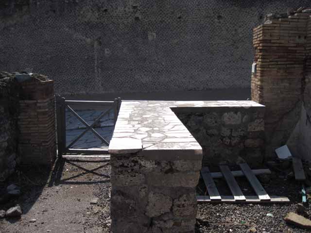 I.2.13 Pompeii. September 2005. Taken from rear. Looking west towards site of ruined small rear room or cupboard, and bar-room onto Via Stabiana and the Little Theatre.  On the left, behind the brick pilaster separating two doorways, would have been the site of the south wall of I.2.13. I.2.14 is visible on the extreme right of the picture.

