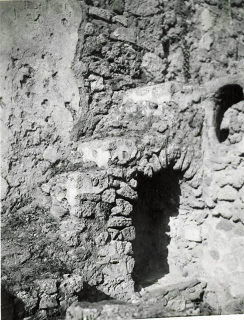 I.2.28 Pompeii. 1935 photo taken by Tatiana Warscher.  North-east corner of garden area, with steps to upper floor and recess below.
See Warscher T., 1935. Codex Topographicus Pompeianus: Regio I.2. (no.57), Rome: DAIR, whose copyright it remains.
According to Warscher, Il lato orientale del peristilio. La scala con sottoscala che conduceva al primo piano e la finestra ovale che illuminava la cucina k.
(translation: The east side of the peristyle. The stairs with understairs, that lead to the first floor, and the oval window that lit the kitchen k.)
