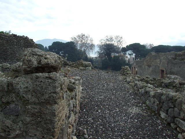I.3.8a Pompeii. September 2010. Looking north along east side, towards kitchen or room in north-east corner. The doorway leads into the kitchen, with remains of hearth and niche in east wall. Photo courtesy of Drew Baker.