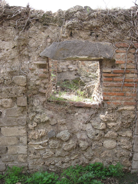 I.3.27 Pompeii. September 2010. Looking north with detail of grindstone in room on south side of bakery room, on east side of oven.  Photo courtesy of Drew Baker.

