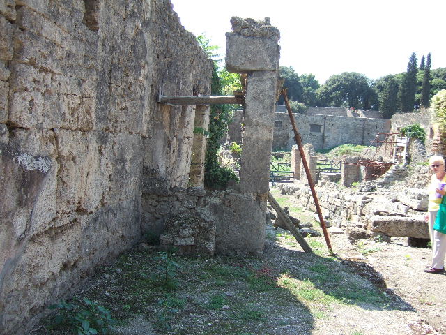I.5.2 Pompeii. September 2010. Looking north towards steps to upper floor, with remaining two stone steps. Note doorway on east wall of shop-room leads under this stairway. Photo courtesy of Drew Baker.

