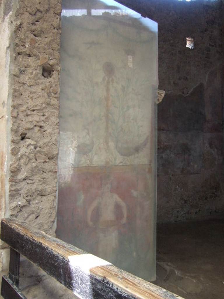 I.6.15 Pompeii. May 2006. Room 9, small garden. Wall on west side with painting with birds, plants and a medallion above a figure holding a basin or bowl.