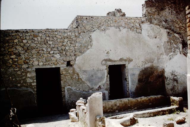 I.12.8 Pompeii. March 2009. Room 9, north-west corner showing five of the six dolia found here. The sixth stands near the latrine in the north-east corner of the peristyle garden.
According to Curtis, five of these containers held the remains of a fish sauce, garum or liquamen. Garum was the product formed from the self-maceration of fish and other small marine animals in salt. Liquamen was a closely related fish sauce.
Several of the amphorae that were also found here also contained a substance similar to that found in the dolia. Maiuri stated that when these vessels were excavated the smell of fish was still fresh. This smell remained strong for some time after the exposure to the air.
The dried fish sauce contained the small bones and vertebrae of anchovies. Although the clear liquid had long since dried up, it left the odour entrapped until released in 1960.
See Curtis, R.I: The Garum shop at Pompeii, In Cronache Pompeiane, V,1979, (p.10)
See Maiuri, A: L’odore della salsa di 2000 anni fa, In Corriere della Sera (Milan), 2 January 1961, p.3
