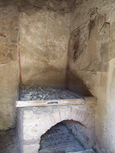 I.12.8 Pompeii.  March 2009.  Room 10.  West wall.  Remains of Lararium, painted with plants and birds. The legs of the Lares used to be visible at the top of the wall, but only their booted legs, the upper parts were destroyed. 
See Giacobello, F., 2008. Larari Pompeiani: Iconografia e culto dei Lari in ambito domestico.  Milano: LED Edizioni.  (p.152-3).