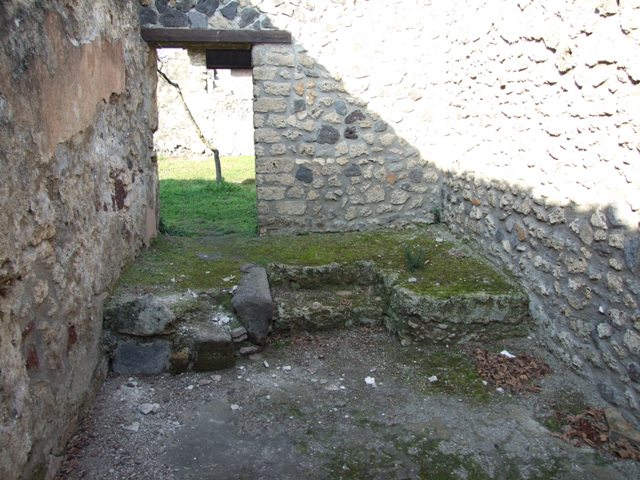 I.12.9 Pompeii. December 2007. East wall of kitchen. According to PPP and Giacobello, on the east wall of the kitchen above the bench was a lararium, now completely disappeared. According to PPP, the Lararium was shown with altar, offerings, a Lar, and a decayed serpent.
According to Giacobello, in the upper part was the figure of the Genius sacrificing near an altar. He was assisted by two people, presumably the camillo and the tibicine. On his left, was a painted Lar with his arm held high, near to him was a large ham. Upon discovery, the serpent near an altar in the lower zone was only partially conserved.  See Giacobello, F., 2008. Larari Pompeiani: Iconografia e culto dei Lari in ambito domestico.  Milano: LED Edizioni. (p.153)   See Bragantini, de Vos, Badoni, 1981. Pitture e Pavimenti di Pompei, Parte 1. Rome: ICCD. (p.176)
