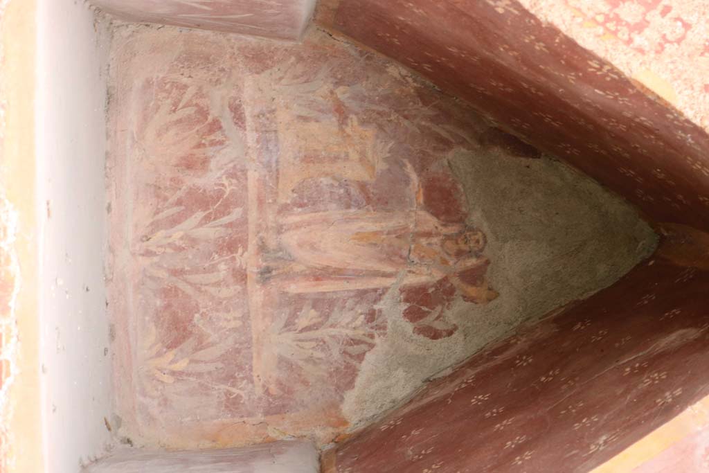 I.14.7 Pompeii. March 2009. Garden area, west wall. Niche Lararium with painting of a god in a long white robe lying on a couch. The right hand holds a branch and the left holds a Patera. To the right is a golden candelabrum. At the front is a three legged table with a bowl of fruit. Above is a garland. See Fröhlich, T., 1991. Lararien und Fassadenbilder in den Vesuvstädten. Mainz: von Zabern. (L34, T:29,3)