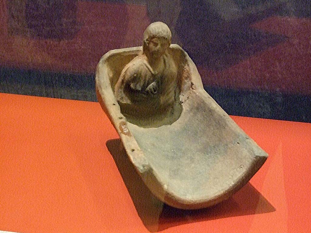 I.14.15 Pompeii. Cradle-shaped terracotta perfume burner with bust of a young boy with amulet around his neck. SAP 34973.
Photographed at “A Day in Pompeii” exhibition at Melbourne Museum. September 2009.
