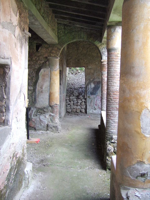 I.17.4 Pompeii.  May 2006. Open area or yard on south side of peristyle garden.  Looking south to stairs, with cupboard underneath, and upper gallery.  The triclinium and a cubiculum are on the left.
