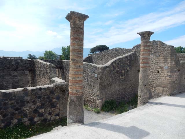 I.16 Pompeii, and I.15 (ahead). Via della Palestra, looking east . Side wall of I.21.1
