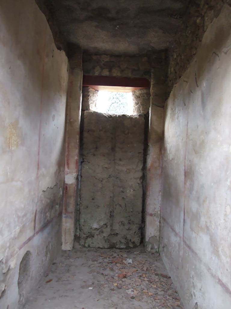 II.4.10 Pompeii. December 2006. Room with blocked door.
When the entrance onto the western roadway was walled up, the wooden door was left closed from the inside.
From this, it was possible to make a mould of the door, and from this it could be seen that it would have had double doors.
