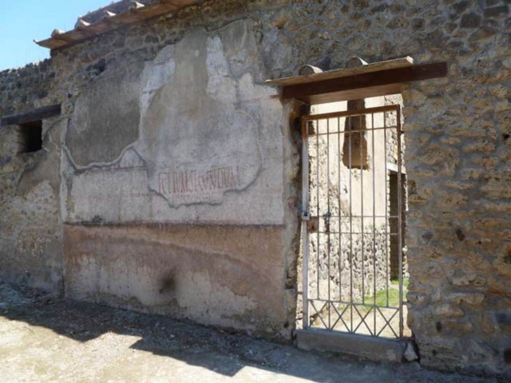 II.4.10 Pompeii. May 2011. Exterior west wall on north side of doorway, showing multiple layers of graffiti or painted plaster. L. Ceium Secundum aed… can be clearly read.
Photo courtesy of Michael Binns.
