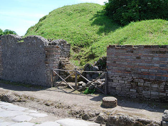 II.5.2 and II.5.1 Pompeii. December 2006. Remains of 4 columns in footpath that probably supported a balcony overhanging Via dell’ Abbondanza. Looking west. 