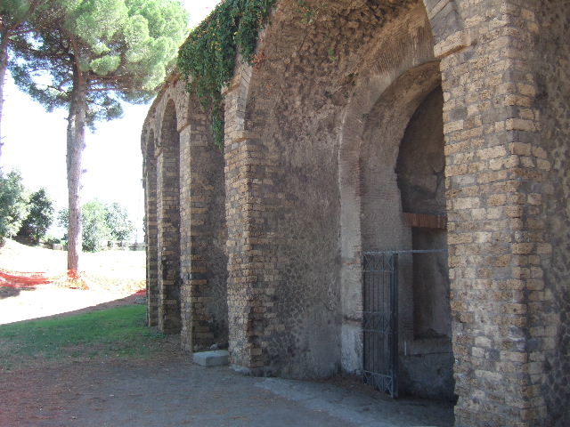 II.6 Pompeii. December 2006. Large rectangular niche, on east side of corridor of Amphitheatre, which had contained a statue of city magistrates. According to Mau, the niches in the north passage were adorned with two portrait statues of Gaius Cuspius Pansa, father and son. These were placed in the niches, in the east and west walls, facing each other. The statues have disappeared but the inscriptions are still readable. See Mau, A., 1907, translated by Kelsey, F. W., Pompeii: Its Life and Art. New York: Macmillan. (p. 219).