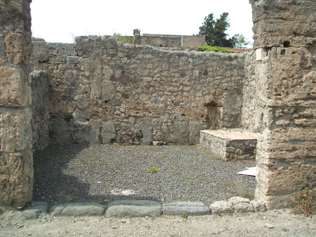 V.2.5 Pompeii.  March 2009.  East side of shop, with podium or hearth and window to V.2.6.