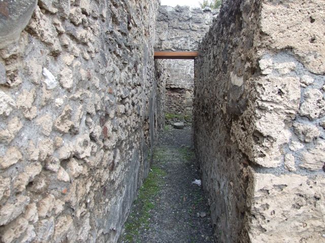V.2.13 Pompeii, March 2009. Hearth in south west corner of thermopolium. According to Boyce, above the hearth was a badly preserved Lararium painting. The Genius was represented sacrificing at an altar. On each side stood a Lar, but only the one on the right was preserved. Further to the right a serpent approached an altar.
The description was from Sogliano published in 1879. Reports in periodicals published in 1894 and 1896 mention only an altar as being visible in a painting. Today, nothing remains.
See Boyce G. K., 1937. Corpus of the Lararia of Pompeii. Rome: MAAR 14. (No. 92 on p34) See Sogliano, A., 1879. Le pitture murali campane scoverte negli anni 1867-1879, Naples.