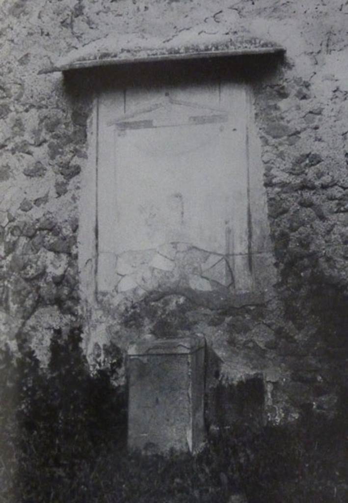 V.2 Pompeii. Casa di Orione. Old undated photograph. Garden 11c. North wall. Lararium.
The Notizie degli Scavi records a panel of white stucco.
On this is painted an aedicula, which Boyce says is painted in blue, yellow, dark red and green.
Within the aedicula is a painting of Giove (Jupiter) seated on a throne.
Underneath is a masonry altar covered with white plaster. 
See Notizie degli Scavi di Antichità, 1894, p. 439.
See Boyce G. K., 1937. Corpus of the Lararia of Pompeii. Rome: MAAR 14.  (96, p.35, Pl 39,3).
