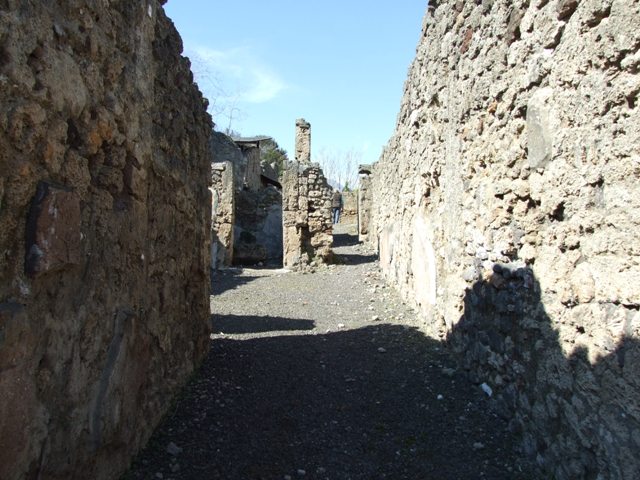 V.3.7 Pompeii.  March 2009.  Looking north across west side of atrium to Doorway to Triclinium, and passageway to the Garden.