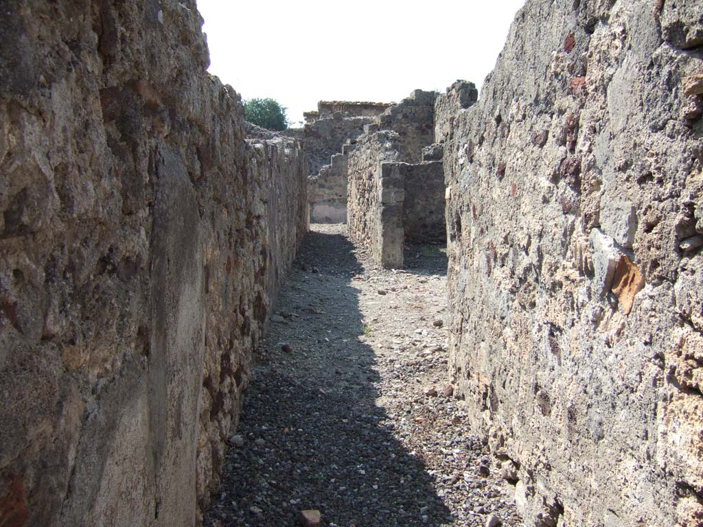 VI.2.26 Pompeii. September 2005. Looking west along entrance corridor towards workshop, on right.
At the end of the corridor can be seen the steps to upper floor, in the yard. 

