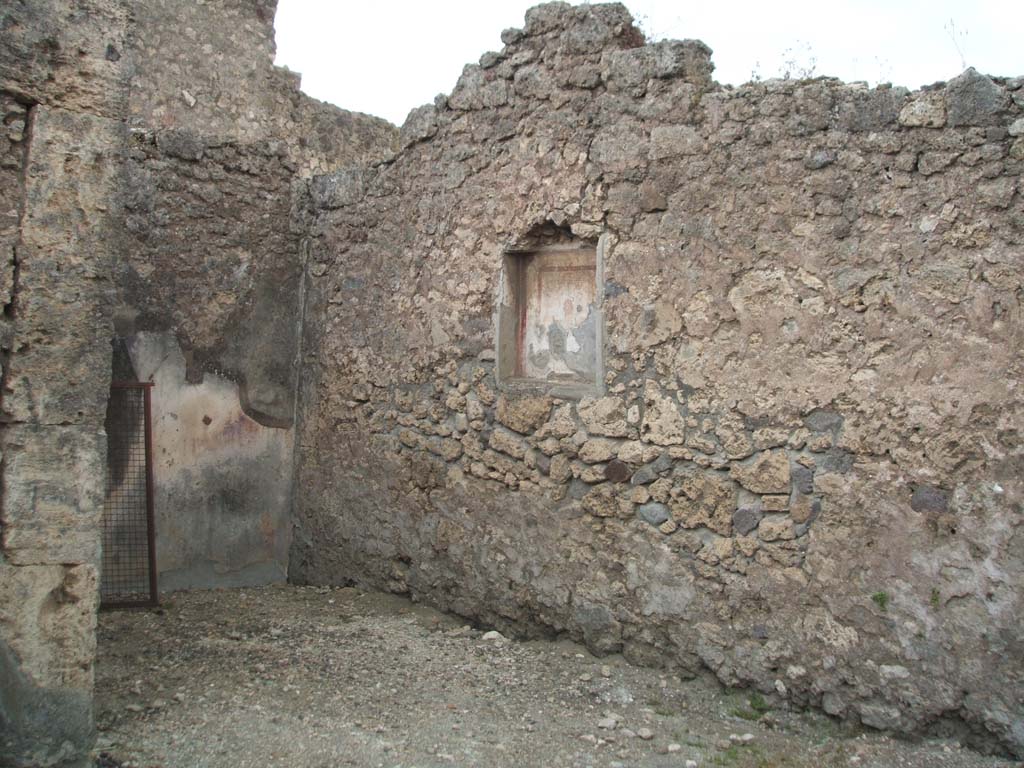 VI.7.9 Pompeii. May 2005. West wall of south ala, with niche with small painting of the head of the Gorgon.
According to Frohlich and Giacobello, on the west wall of the atrium, was a niche with a painted mask on a white background.
A painted lararium was also documented but of this there is no trace, according to them.
See Fröhlich, T., 1991. Lararien und Fassadenbilder in den Vesuvstädten. Mainz: von Zabern. (L63, Picture 34,1)
See Giacobello, F., 2008. Larari Pompeiani: Iconografia e culto dei Lari in ambito domestico.  Milano: LED Edizioni. (p.242)
According to Sogliano, in the kitchen was a painted lararium of an altar and a serpent nearby.
See Sogliano, A., 1879. Le pitture murali campane scoverte negli anni 1867-79. Napoli: (p.17, no.48).
(The kitchen would have been on the north side, at the rear of the stairs, and has not yet been photographed).
According to Boyce, Helbig wrongly assigned the shrine from VI.7.7, to VI.7.9 (see VI.7.7)
See Boyce G. K., 1937. Corpus of the Lararia of Pompeii. Rome: MAAR 14. (p.47, no.163, note 1) 
