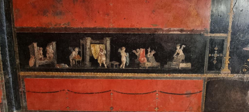 VI.15.1 Pompeii. January 2023. 
East wall in north-east corner with panel showing cupids cleaning clothes in a fullery. Photo courtesy of Miriam Colomer.
