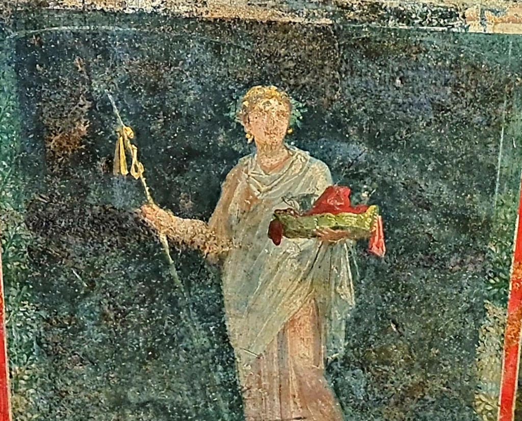 VI.15.1 Pompeii. April 2023. 
Detail of painted female figure or priestess holding implements of sacrifice, from lower east wall (zoccolo) at north end.
Photo courtesy of Giuseppe Ciaramella.
