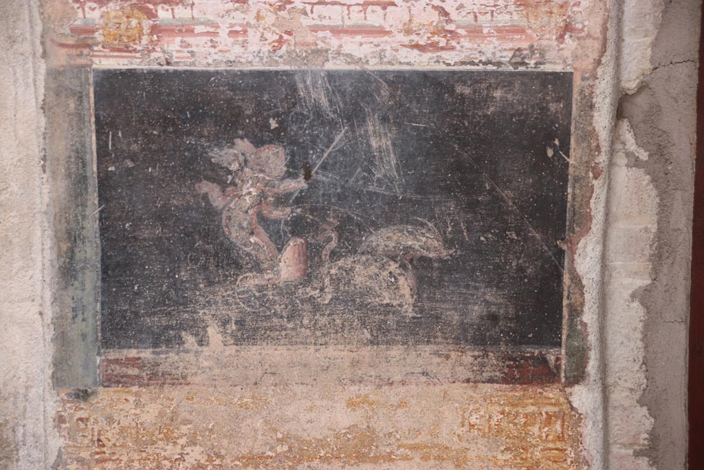 VI.15.1 Pompeii. October 2023.  
East wall of atrium, detail of cupid and dolphins from panel between entrance corridor and cubiculum on south side of entrance.
Photo courtesy of Klaus Heese.
