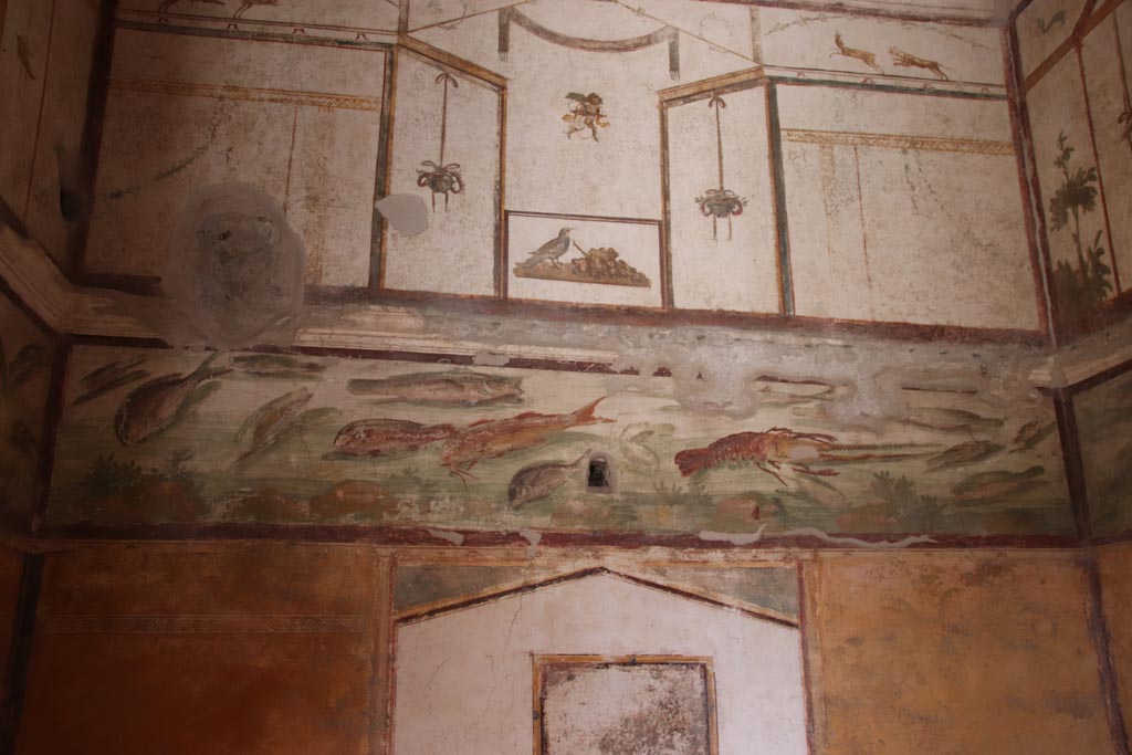 VI.15.1 Pompeii. October 2023. Looking east in bedroom towards frieze of fishes on upper east wall. Photo courtesy of Klaus Heese.