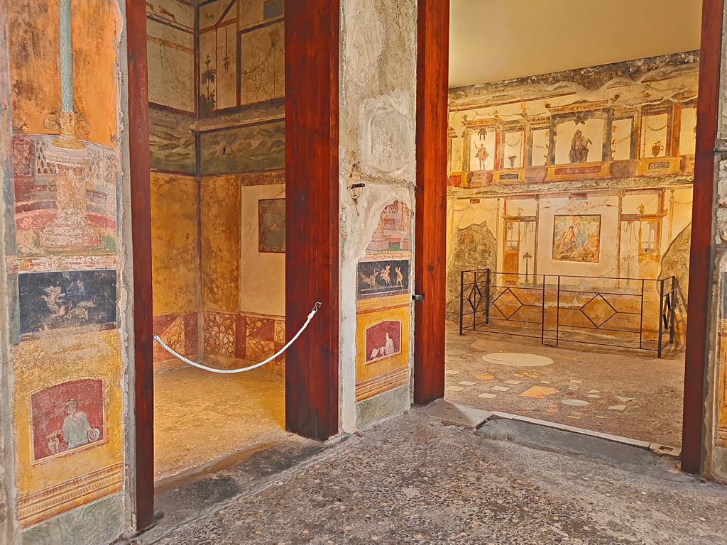 VI.15.1 Pompeii. April 2023. 
South-east corner of atrium with doorway into cubiculum (d) on left, and into oecus (e), on right. Photo courtesy of Giuseppe Ciaramella.
