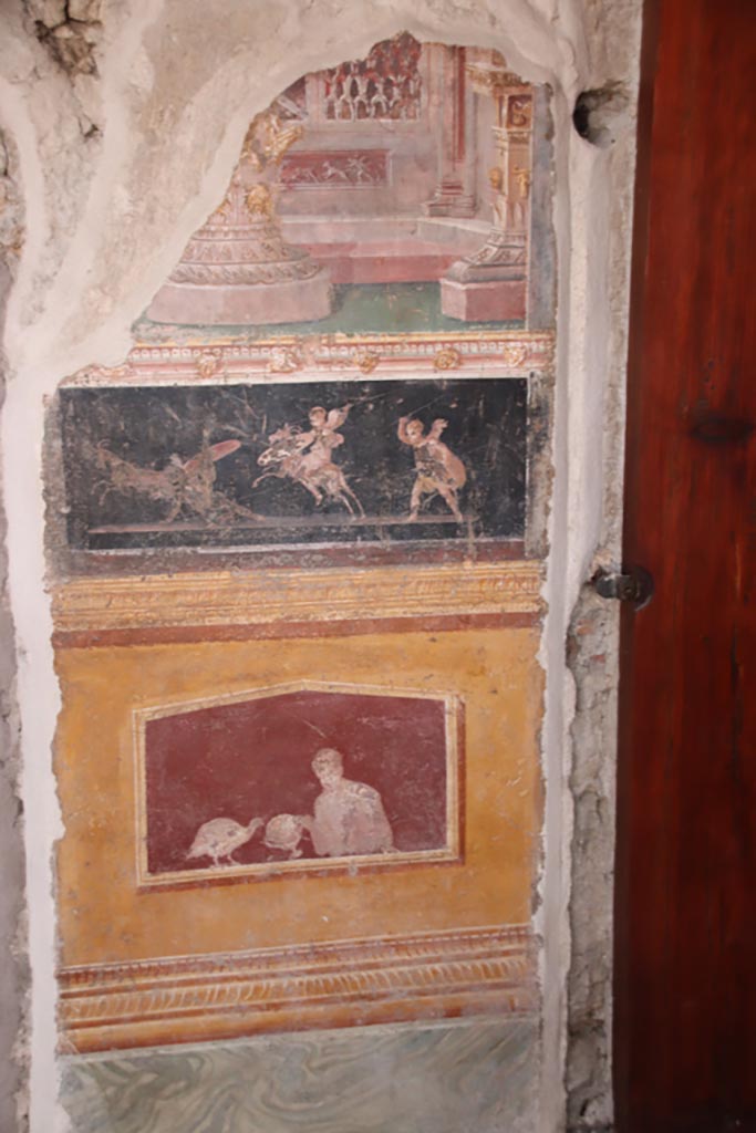 VI.15.1 Pompeii. October 2023.  
East wall of atrium, detail from panel between cubiculum (d) on left, and into oecus (e), on right.
Photo courtesy of Klaus Heese.
