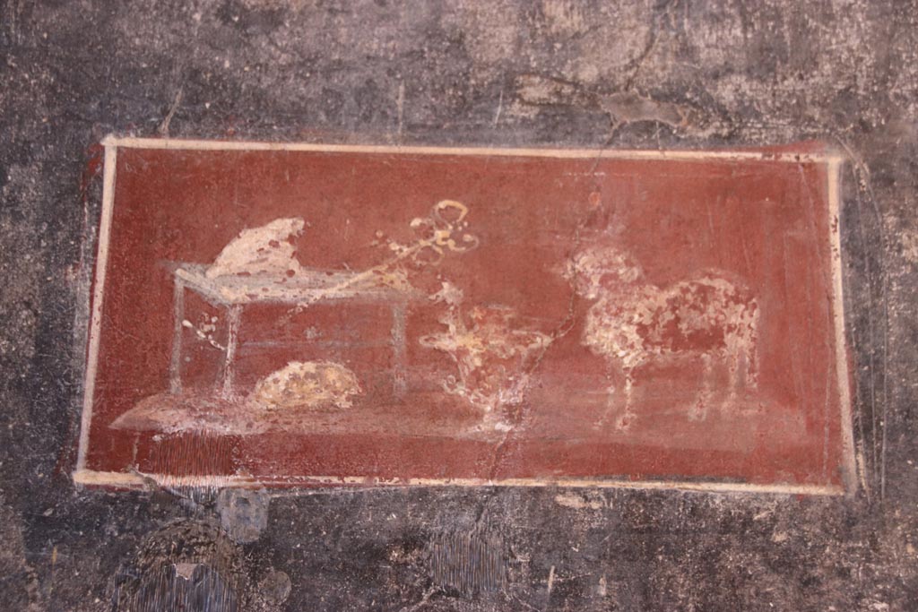 VI.15.1 Pompeii. December 2006. Painted panel from north wall of vestibule. According to Sogliano, the two black panels on the north wall also contained a small rectangular panel on a red background. This represented the attributes of Mercury, being a ram, and a vase, and placed on a table were the caduceus and the purse. Under the table, on the floor was a tortoise.
See Sogliano, A: La Casa dei Vettii in Pompei, 1898, (p.237)
