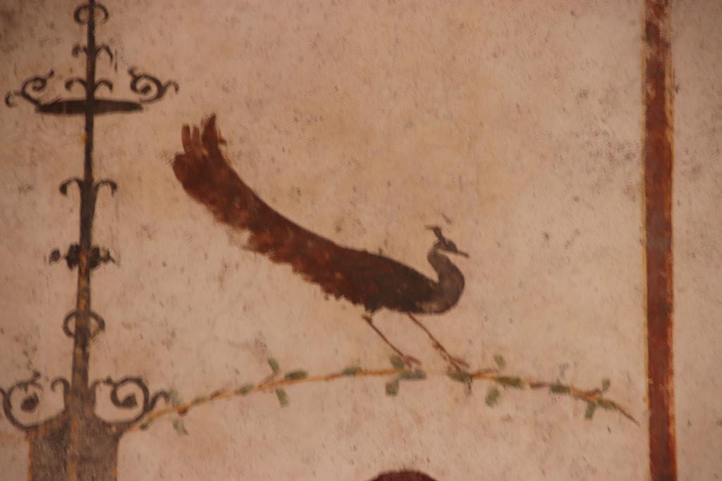 VI.15.1 Pompeii. October 2023. 
White cubiculum “u”, detail of painted peacock from north side of central figure on upper east wall. Photo courtesy of Klaus Heese.

