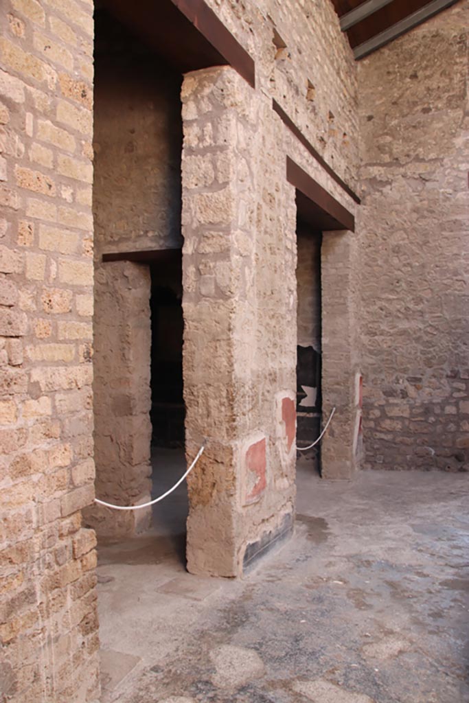 VI.15.1 Pompeii. October 2023. Looking south along east side of portico.
The doorway on the left is into the cubiculum “u”. The doorway in the centre is into the triclinium “t”.
Photo courtesy of Klaus Heese. 
