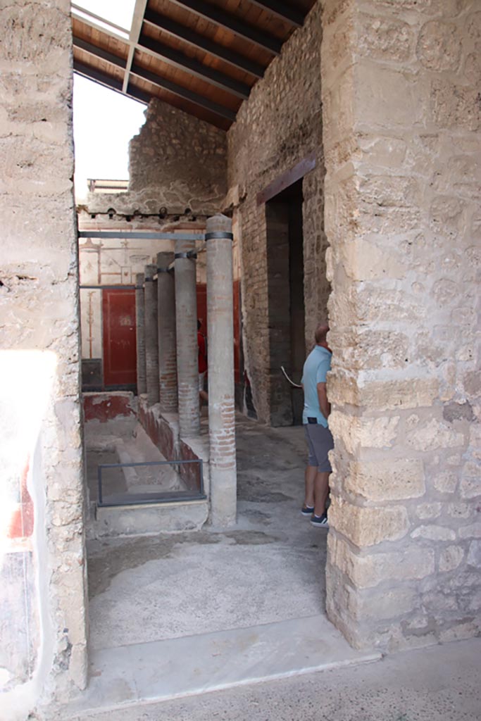 VI.15.1 Pompeii. October 2023. 
Looking north to doorway into small yard with portico, from north portico of peristyle garden.
Photo courtesy of Klaus Heese.
