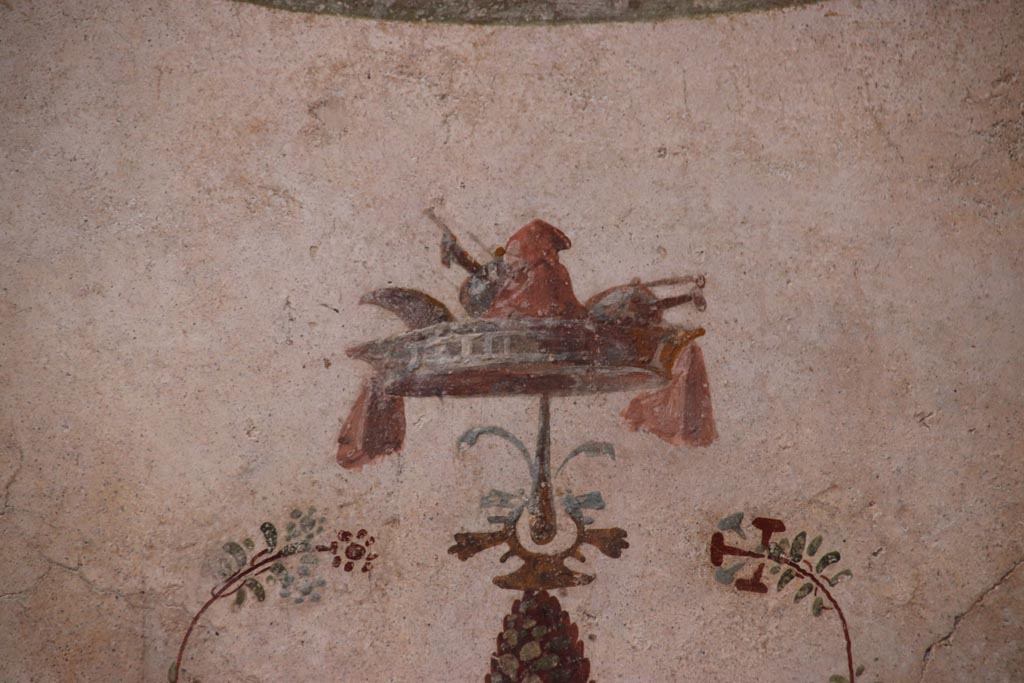 VI.15.1 Pompeii. October 2023. 
North wall of small courtyard/peristyle garden “s”, detail from top of candelabra. Photo courtesy of Klaus Heese. 
