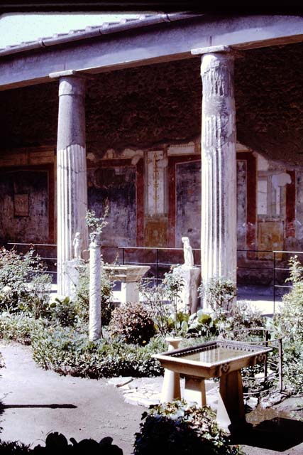 VI.15.1 Pompeii. December 2006. Detail of painted pillar between Peristyle and Atrium with figure holding a cup.
