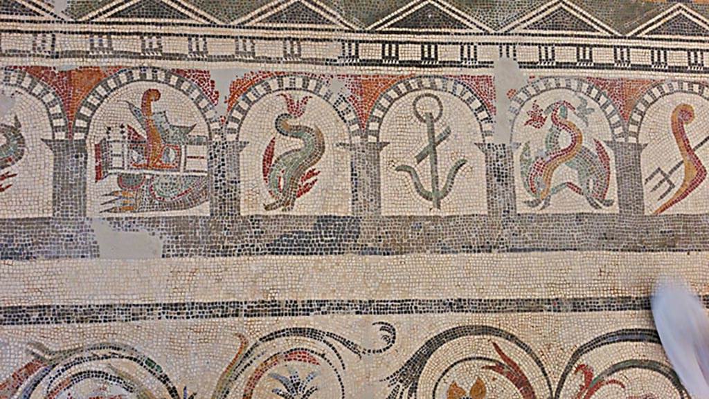 VI 17.10 Pompeii? July 2019. 
Detail from mosaic of “doors”, starting with a stern of a ship with rudder, a dolphin, and anchor, two dolphins, and a trident. 
On display in Naples Archaeological Museum. Photo courtesy of Giuseppe Ciaramella.
