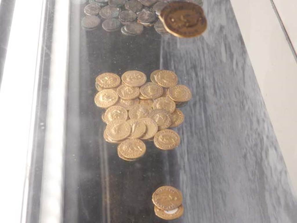 VI.17.42, Pompeii, May 2018. Pile of silver coins, top of photo, pile of gold coins, centre and lower of photo.
Photo courtesy of Buzz Ferebee.

