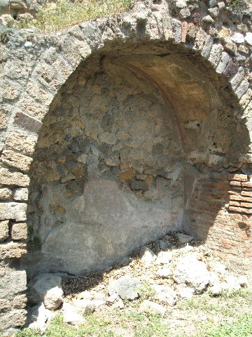 VII.2.7 Pompeii.  Shop.  May 2005.  Painted plaster in arched niche under stone staircase on north wall.