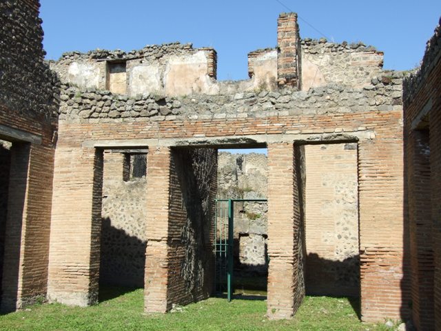 VII.2.18 Pompeii. March 2009. Room 9, upper floor apartment, latrine in north wall of upper floor. According to Hobson, a total of 15 upper storey latrines have been identified in the city, including this one. He says that these latrines would seem to have been placed near to the top of the staircase, and would have been placed in narrow plastered niches with terracotta downpipes inserted into the walls to carry the waste product down into the cesspit. This latrine shows the slots in the sides of the niche where the wooden seat fitted, and the tapering, easily sluiced plaster below the seat.
See Hobson, B., 2009. Latrinae et foricae: Toilets in the Roman World. London; Duckworth. (p.75-6).
