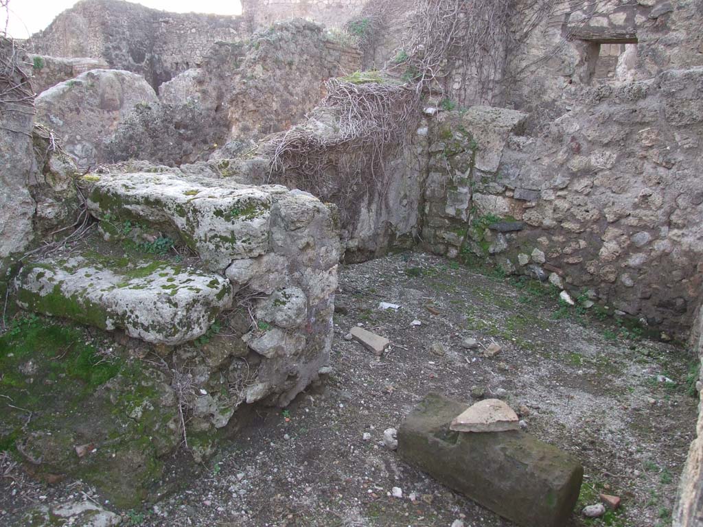 VII.2.23 Pompeii. December 2006. Looking west towards room in south-west corner of atrium, on south side of entrance corridor.
On the left is the base of three steps leading to upper floor. 
At the rear of the wall, on the right, is the latrine which was entered through the doorway from the entrance vestibule/corridor.  
