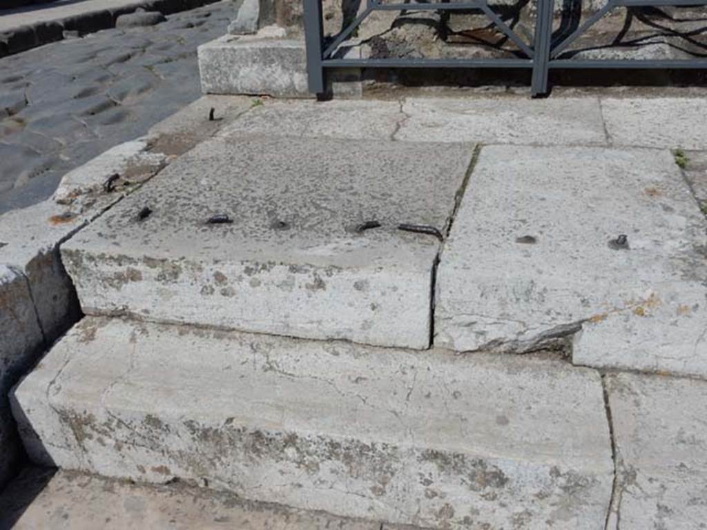 VII.4.1 Pompeii. May 2018. Steps and podium at north end. Photo courtesy of Buzz Ferebee.
According to Niccolini, All the space of the plinth that protrudes forward from the closed base had an iron latticework, the remains of which can still be seen surround this space, and one entered through two gates.
See Niccolini F, 1854. Le case ed i monumenti di Pompei: Volume Primo. Napoli, Tempio della Fortuna, Tav. I, p. 2.

