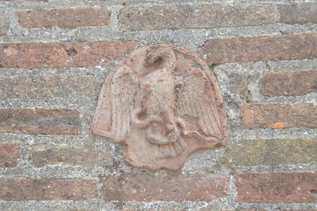 VII.4.55/56 Pompeii. March 2018. Terracotta plaque with eagle, on pilaster on east side of entrance.
Foto Taylor Lauritsen, ERC Grant 681269 DCOR.
