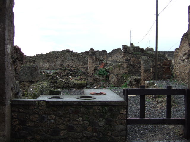 VII.6.20 Pompeii. March 2009. Looking west towards site of rear room, and small yard or garden. This site would be approximately under the pile of stones. According to Eschebach, on the north side (right) would have been a separate steps to the upper floor dwelling above the doorway to VII.6.19. On the west side would have been a rear room, another stairs to the upper floor, a latrine and a small yard and garden.
See Eschebach, L., 1993. Gebäudeverzeichnis und Stadtplan der antiken Stadt Pompeji. Köln: Böhlau. (p.296)
