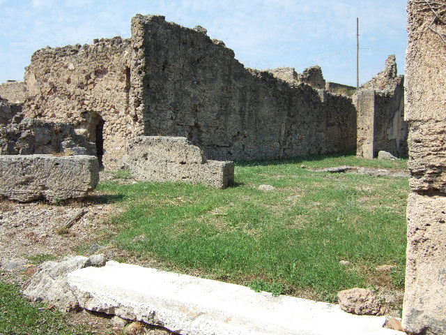 VII.6.28 Pompeii. About 1910 South-west corner of the peristyle.
In the picture can be seen a low wall or threshold of the tablinum, the andron and the doorway to room 7. Also visible is a masonry altar. This area was devastated by bombing in 1943. Photograph courtesy of Soprintendenza Speciale per i Beni Archeologici di Napoli e Pompei. Negative number C369.
According to Boyce, near the south-west corner of the peristyle stood a rectangular masonry altar, coated with stucco. On the top of it, traces of burning were visible at the time of excavation. He also said that holes found in the earth near the altar were explained by Spano (Not.Scavi) as being the decomposed roots of a large tree. Spano thought this may have been an arbour sacra, which may have been honoured by sacrifice upon the altar. See Boyce G. K., 1937. Corpus of the Lararia of Pompeii. Rome: MAAR 14. (p.67, no.291) Not.Scavi, 1910, 466f and fig.9,9a.